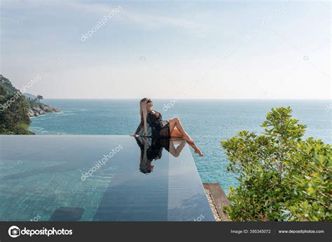 Slender Beautiful Blonde Relaxes In The Infinity Pool At The Resort Stock Photo By