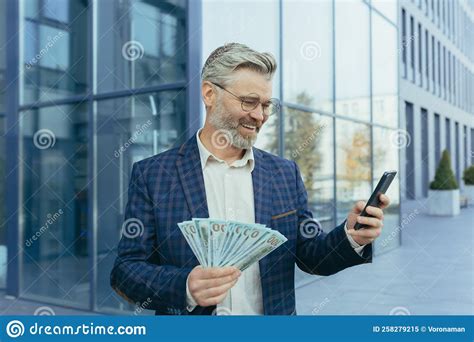 Happy Mature Gray Haired Businessman Holding Winnings Money Cash In