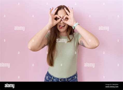 Beautiful Brunette Woman Standing Over Pink Background Doing Ok Gesture