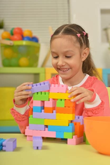 Niña jugando con bloques de plástico Foto Premium