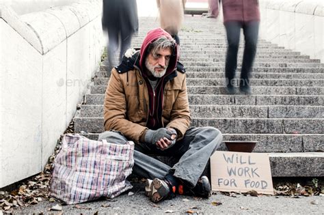 Homeless Beggar Man Sitting Outdoors In City Asking For Money Donation