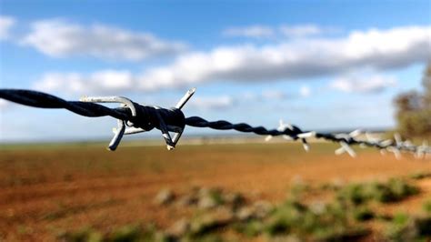 Premium Photo Barbed Wire On Field Against Sky