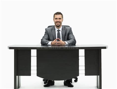 Confident Businessman Sitting Behind A Desk Isolated On White Stock