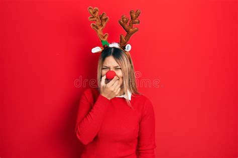 Beautiful Hispanic Woman Wearing Deer Christmas Hat And Red Nose