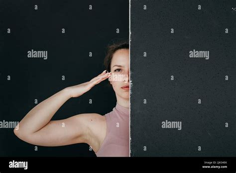 Une belle brunette sort de derrière un écran noir Portrait en gros plan d une jeune fille