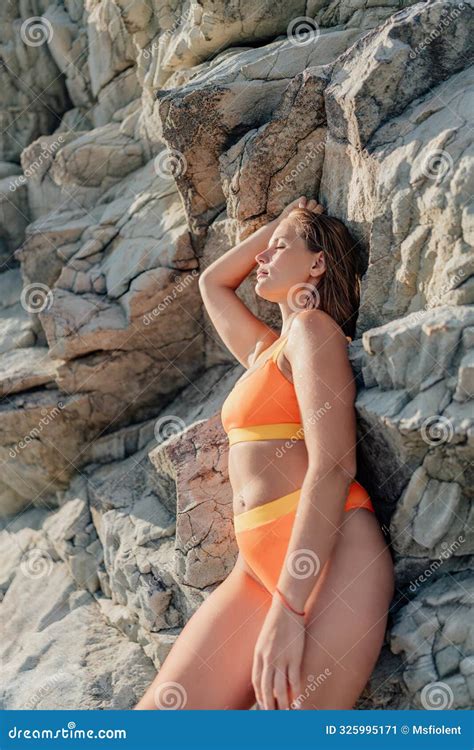 A Woman In A Bikini Is Laying On A Rock Stock Image Image Of Slim Ocean