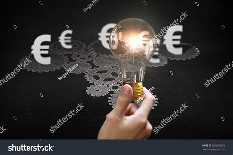 Gears Mechanism And Glowing Light Bulb On Dark Background Stock Photo