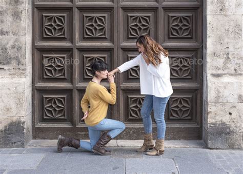 Lesbian Couple On The Street One Of Them Kneels Down And Kisses Her