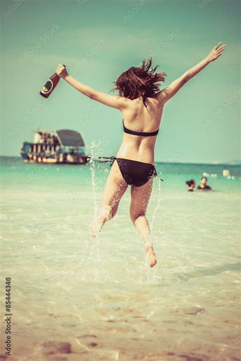 Sexy Asian girl in bikini is jumping on the vintage beach shore 素材庫相片 Adobe Stock