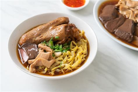 Premium Photo Egg Noodles With Stewed And Braised Duck In Brown Soup