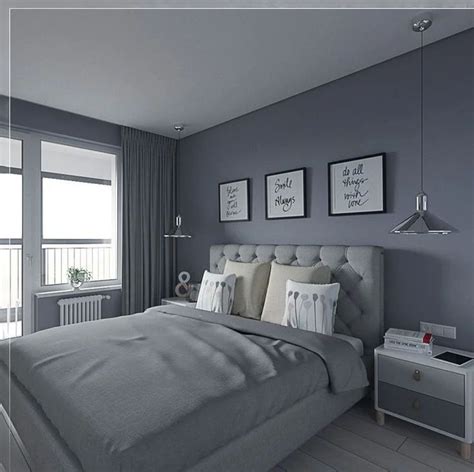 A Bedroom With Gray Walls And White Bedding Two Pictures Hanging On