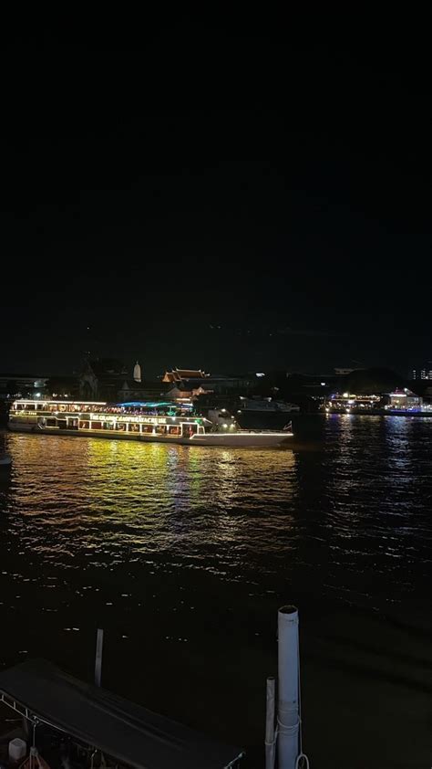 A Large Boat Floating On Top Of A River At Night