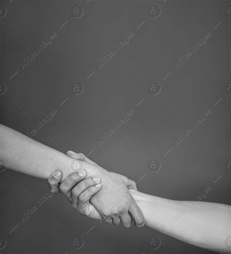 Man And Woman Holding Hands Together On Grey Background Black And