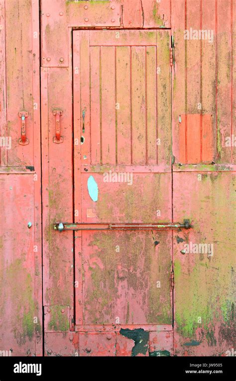 An Old Weather Worn And Beaten Wooden Planked Door With Bolt Across The