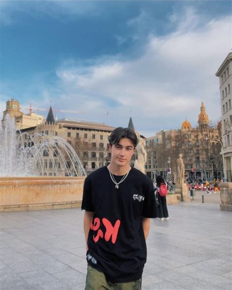 a young man standing in front of a fountain