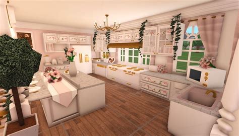 The Kitchen Is Decorated In White And Pink Colors With Gold Trimmings