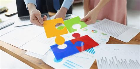 Premium Photo | Coworkers solving jigsaw puzzle on workplace colourful ...