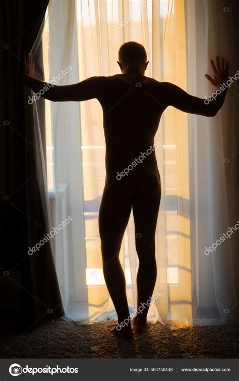 Silhouette gay sexy Jeune homme musclé nu posant sur la fenêtre sous