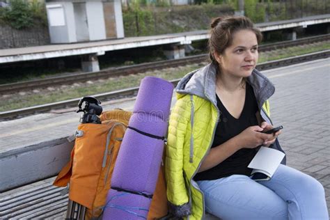 A Menina Senta Se Uma Trouxa E Um Equipamento De Acampamento Foto