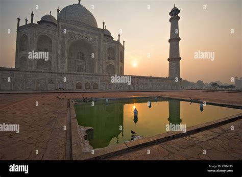 Unusual Angle Of Taj Mahal At Sunrise With Pond In Foreground Stock