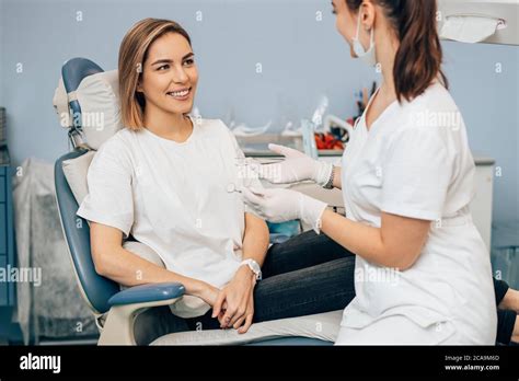 Friendly Dentist Woman Treating Beautiful Patient In Dental Office