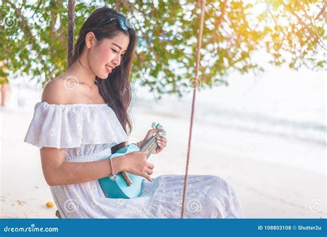 Beautiful Young Asian Woman Playing With Ukulele And Relax On Th Stock