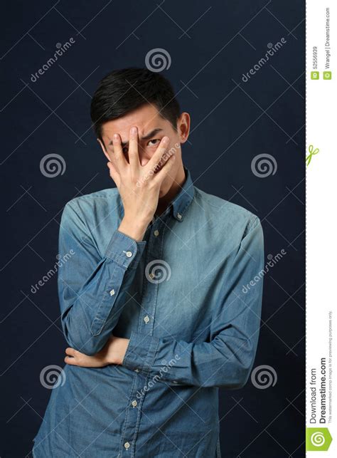 Disappointed Young Asian Man Covering His Face By Palm Stock Image