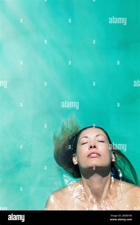 Woman Relaxing In The Pool Water A Beautiful Woman Floating In Water