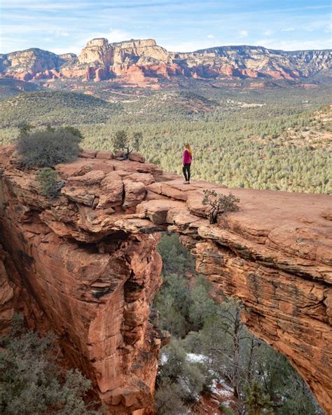 A Person Standing On The Edge Of A Cliff