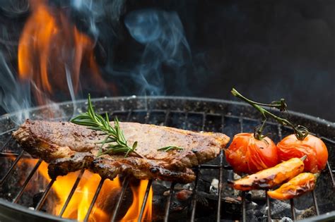 Steak De Boeuf Sur Grille Grill Flammes Sur Fond Avec Tomates Au