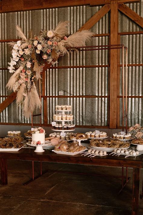 A Table Topped With Cakes And Desserts Next To A Tall Vase Filled With