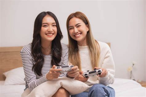 Close Up Hand Of Two Female Holding Hands Two Girls Sitting On Bed Hand