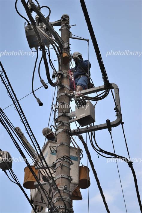 電柱の高所でおこなう電線の工事 写真素材 1295967 フォトライブラリー Photolibrary