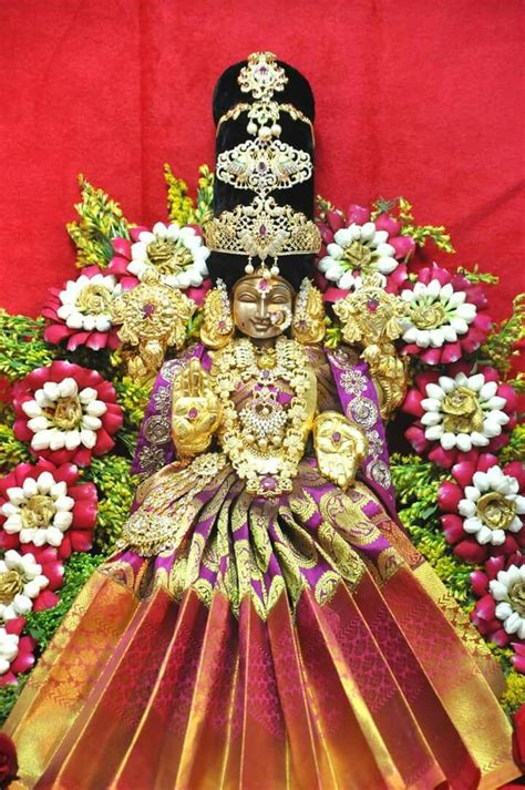 An Idol Is Displayed With Flowers In The Background