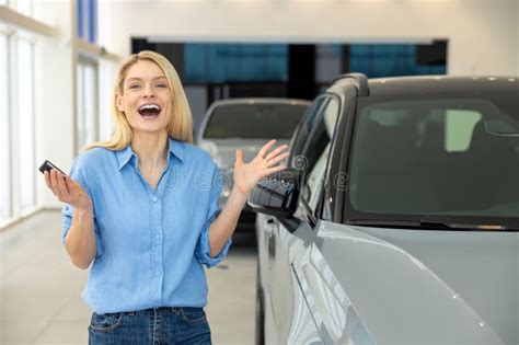 Pretty Long Haired Blonde Woman Near A New Car Looking Enjoyed And Excited Stock Image Image