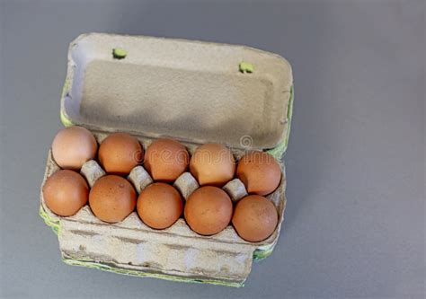 Dozen Brown Eggs In A Cardboard Container On A Gray Background Stock