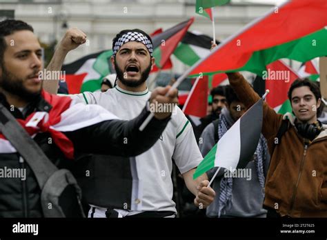 A Man Chants Slogans And Waves A Palestinian Flag During The March Of