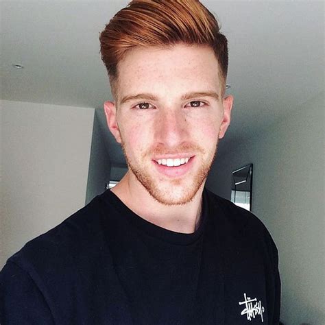 A Man With Red Hair Is Smiling At The Camera While Wearing A Black T