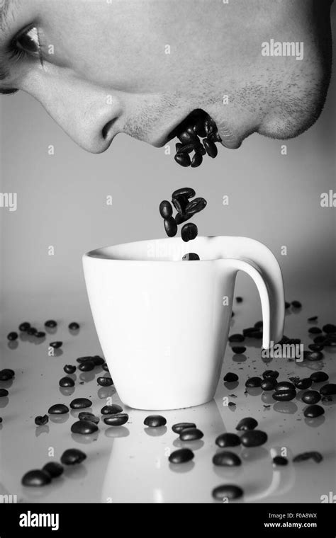 Person Is Spitting Coffee Beans Into The Coffee Cup Stock Photo Alamy