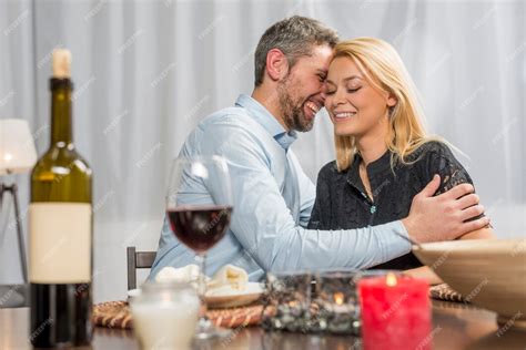 Homme Souriant Embrassant Une Femme Joyeuse à La Table Photo Gratuite