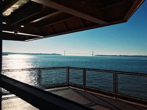 The Sun Shines On The Water And Bridge In The Distance