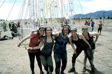 Four Women Posing For A Photo In Front Of A Ferris Wheel