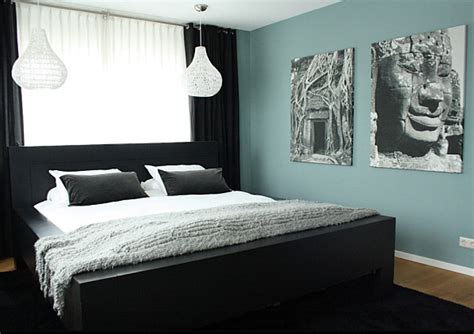 Black contrasts a soothing blue-green bedroom wall