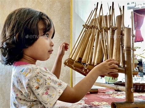 A Girl Plays Angklung A Traditional Musical Instrument Made Of Bamboo