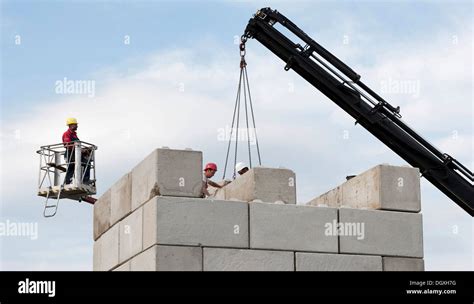 Construction Workers Stacking Concrete Blocks During A Building Site