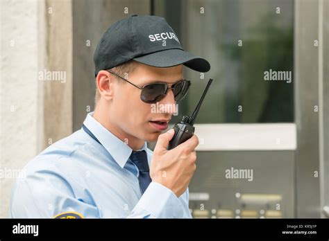 Security Guard Talking On Walkie Talkie Stock Photo Alamy