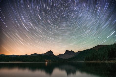 Lago à noite incrível céu estrelado e trilhas reflexos na água