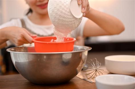 La mujer está horneando cupcakes en su cocina preparando su harina de