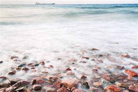 Premium Photo | Cobble stone beach of red sea on sunset