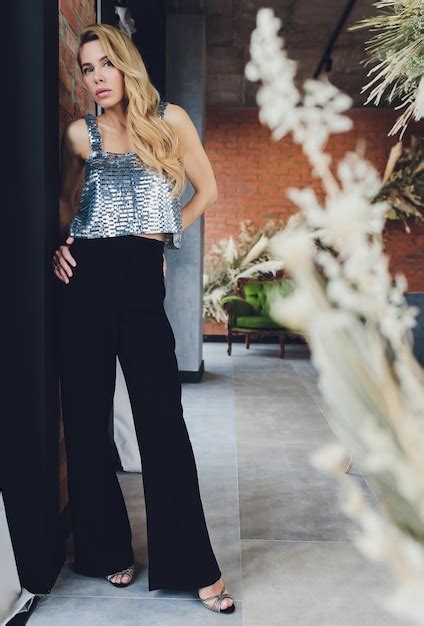 Belle Femme Blonde En Vêtements Noirs Avec Des Talons Se Tient Près De La Vue Arrière De La